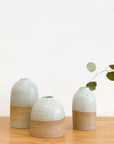 A cluster of Tomoro Morisaki's organic and rounded bud vases with dry leaf